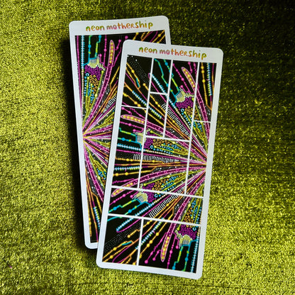 Two colorful sticker sheets with abstract designs on a green textured surface
