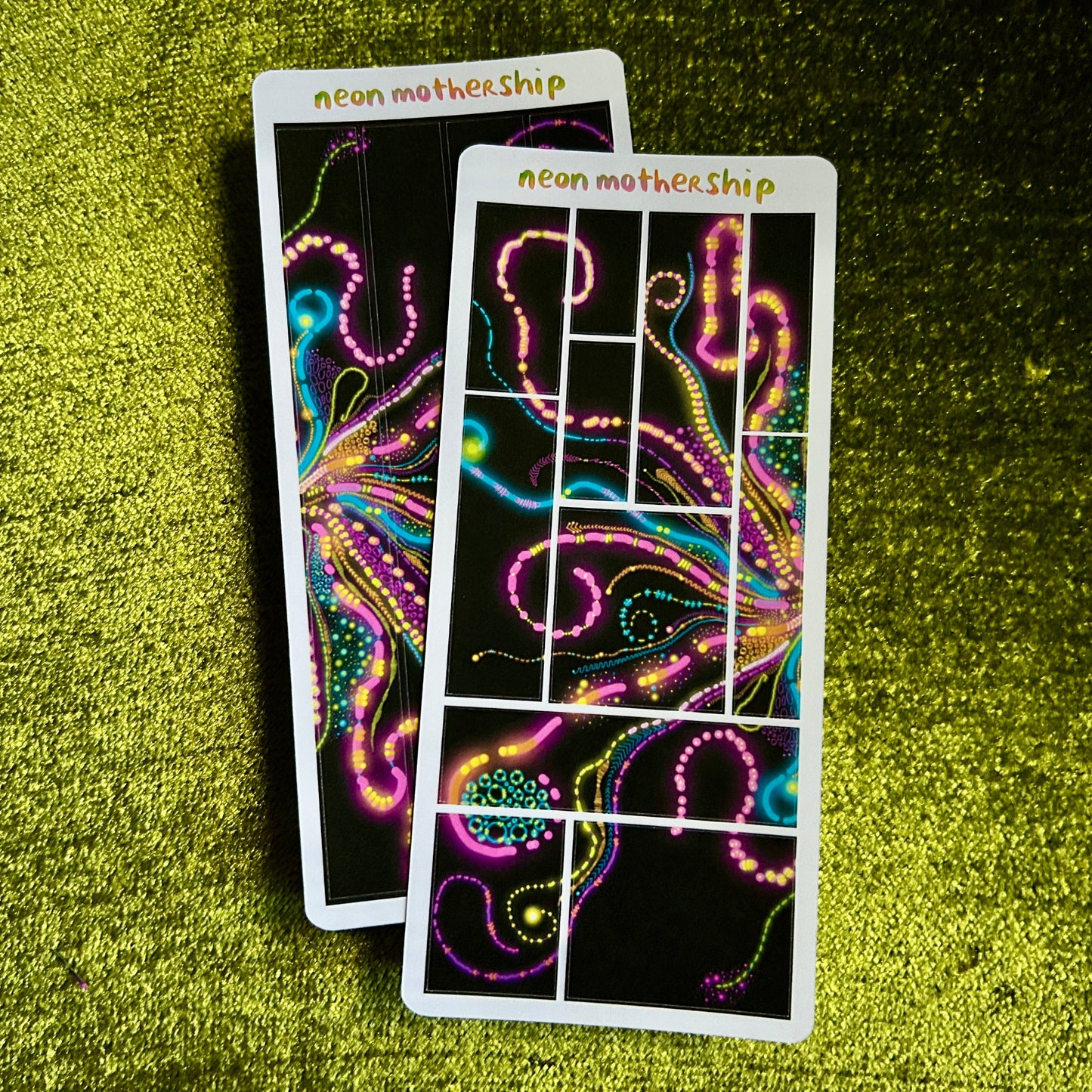 Two colorful sticker sheets with neon patterns on a green textured surface