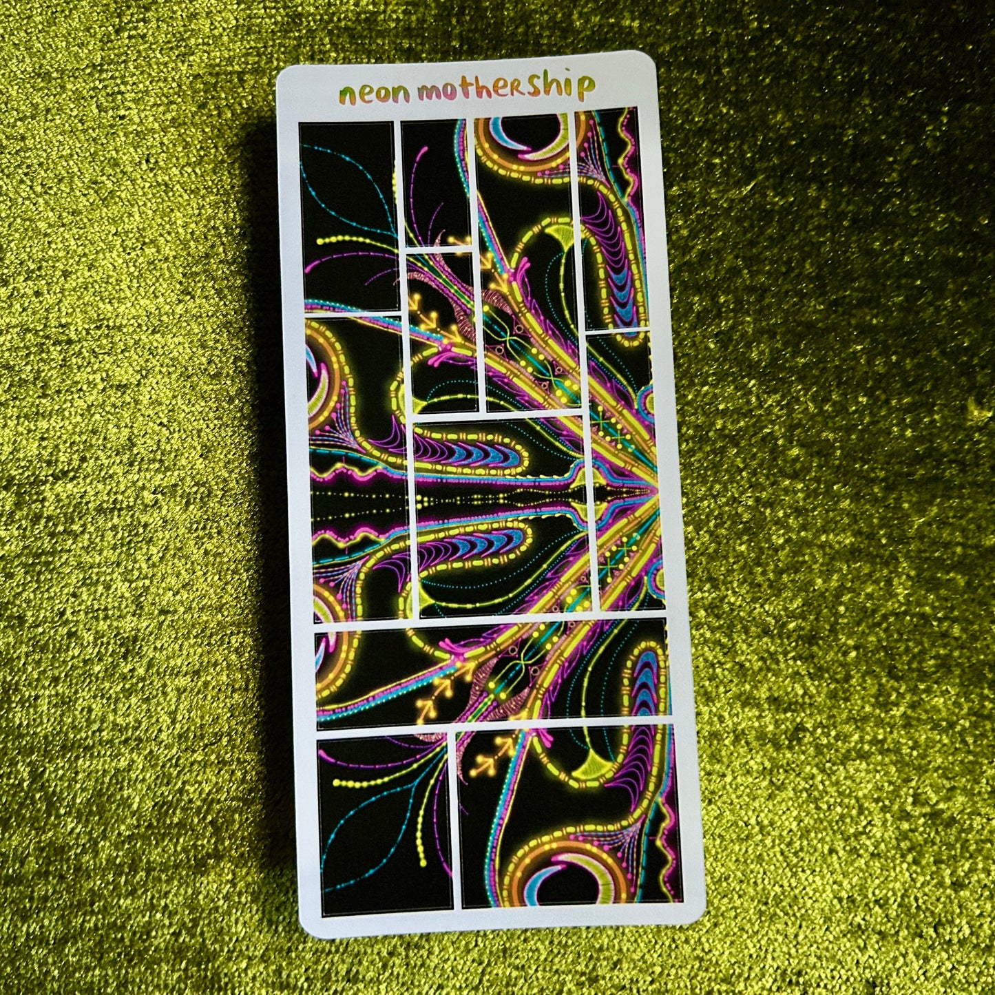 sticker sheet with colorful design on a green textured surface