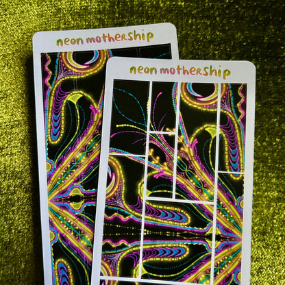 Two neon 'neon mothership' sticker sheets on a green textured surface