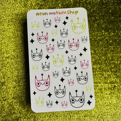 Card with neon motherhip spacecat design on a green textured surface