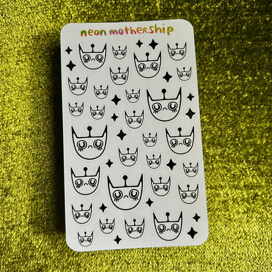 sticker sheet with black and white designs on a green textured surface
