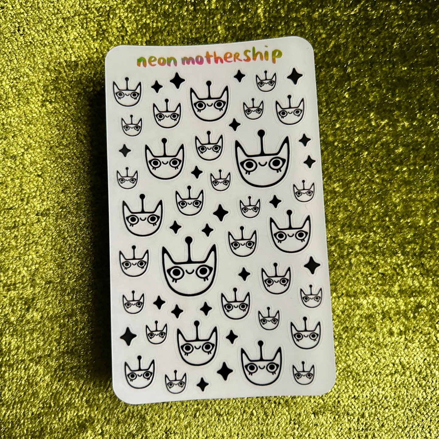 Sticker sheet with black and white patterns on a green glittery background