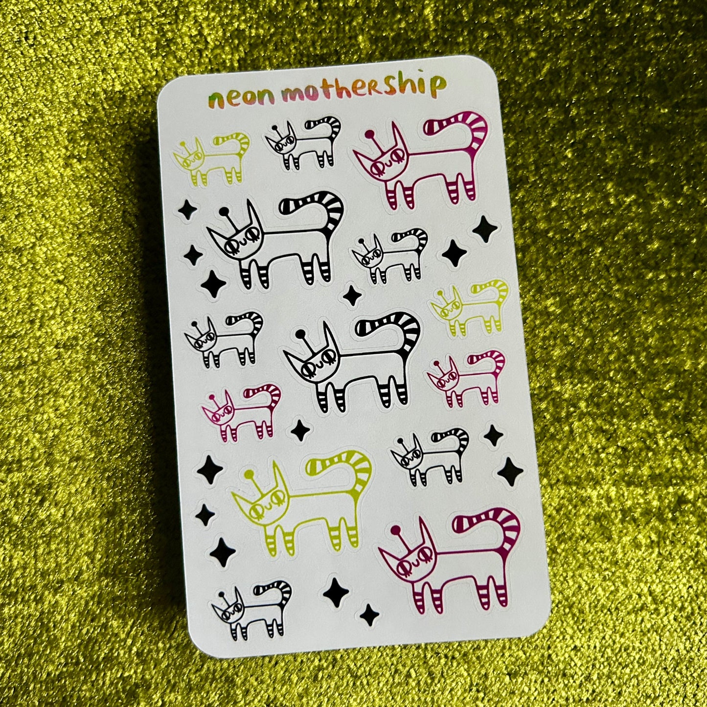 sticker sheet with animal illustrations and 'neon mothership' branding on a green textured background