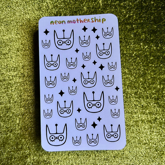 Sticker sheet with black patterns and cats on a green textured background