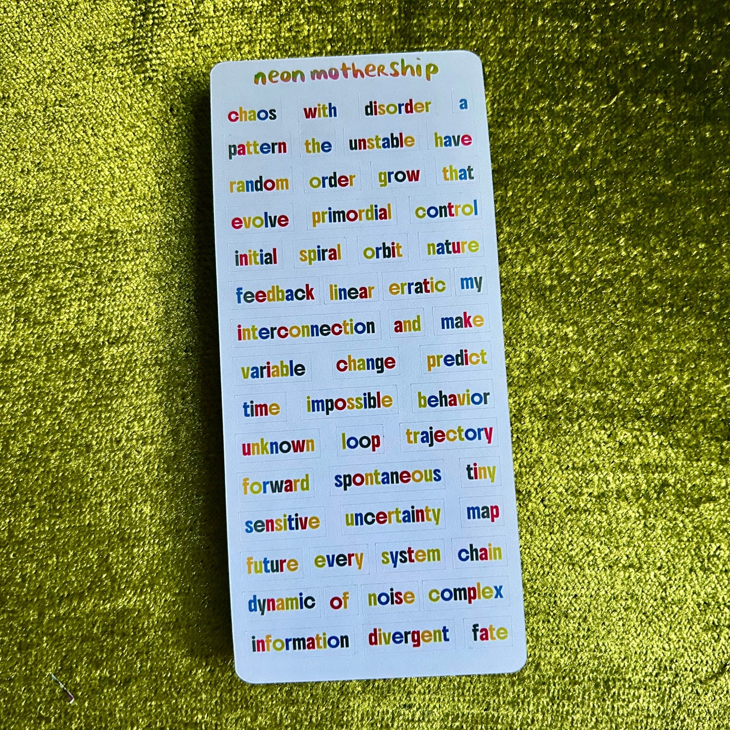 Colorful text sticker sheet on a green textured background