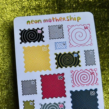 Sheet of colorful stickers with spiral designs on a green textured background
