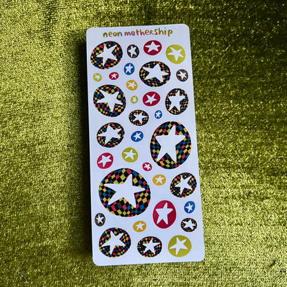 Sheet of colorful star-shaped stickers on a green textured background
