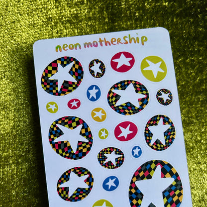 Sheet of colorful star-shaped stickers with 'neon mothership' branding on a green textured background.