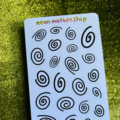Sheet of black spiral patterns on a blue card with 'neon mothership' branding, against a green textured background.