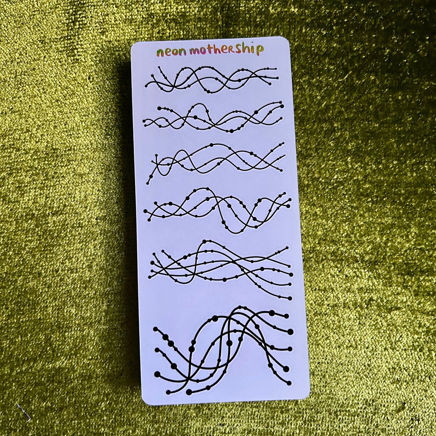 Card with wavy line designs on a green textured background