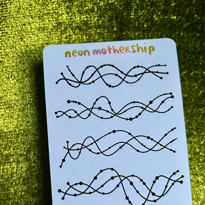 Sheet of black wavy line designs on a white sticker sheet with 'neon mothership' text, against a green textured background.