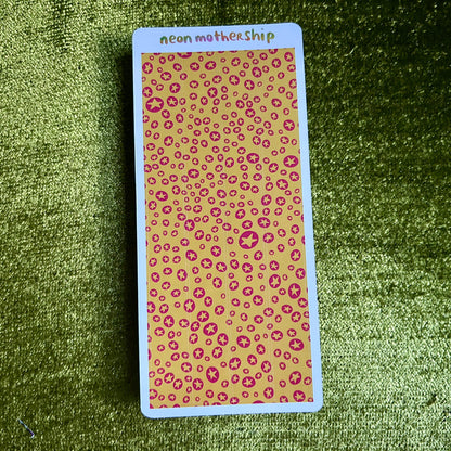 Card with pink star print pattern on a green textured surface