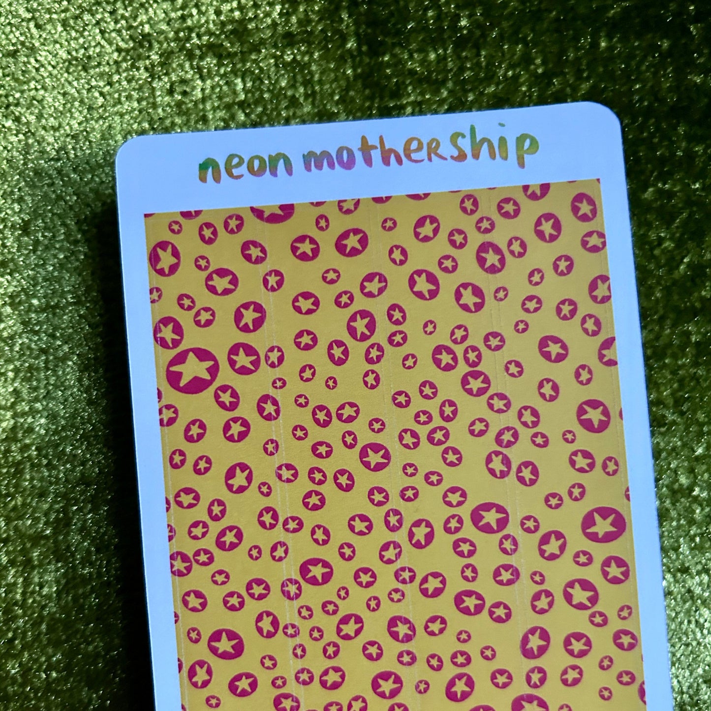 Card with 'neon mothership' text on a green textured surface