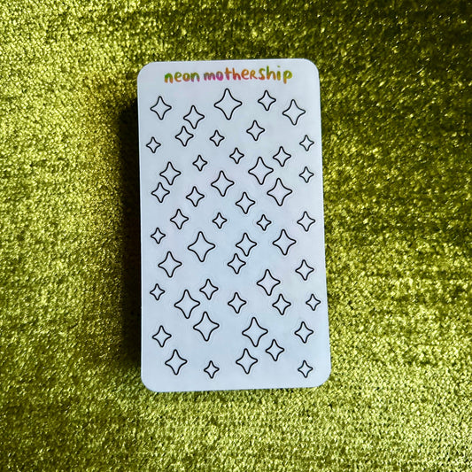 small sticker sheet with star patterns on a green textured surface