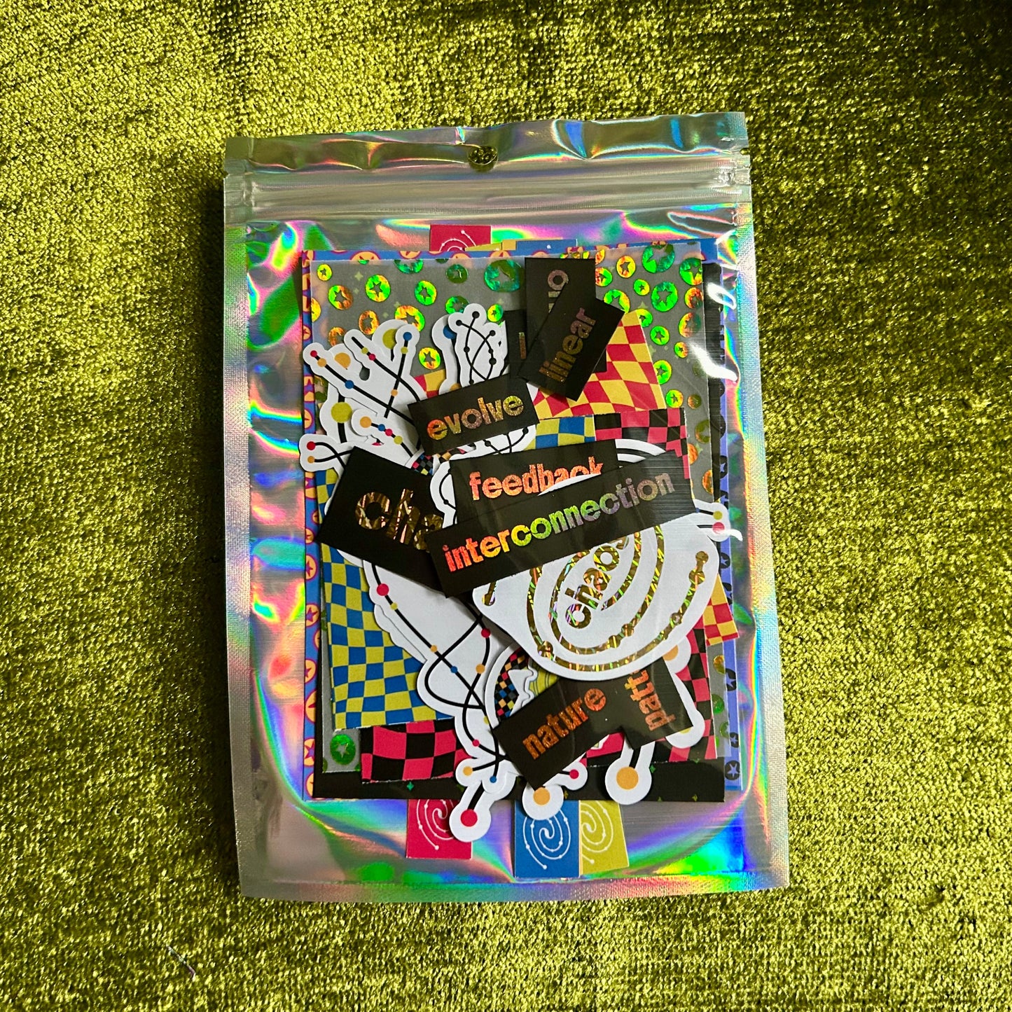 Holographic packaging with stickers on a green textured background