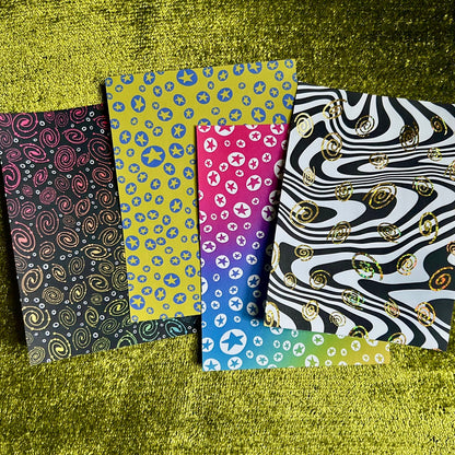 Four patterned sticker sheets on a textured green surface