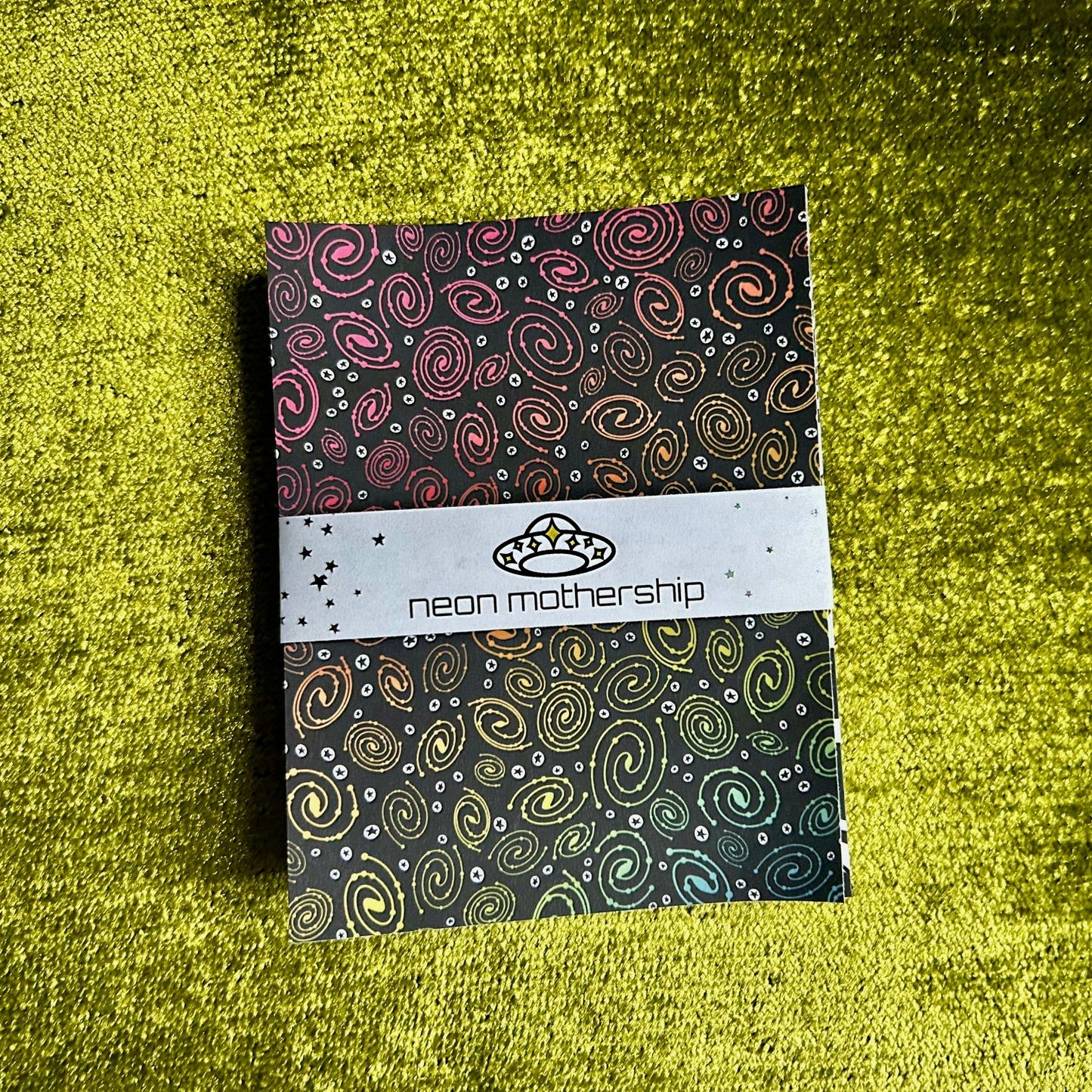 sticker paper with colorful galaxy pattern on a green textured surface