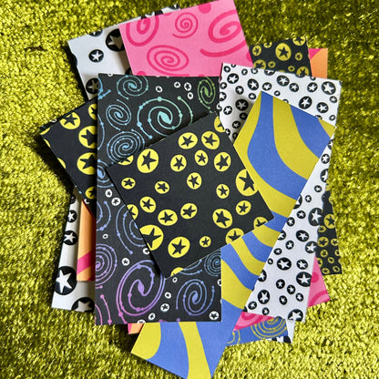 Collection of colorful sticker scraps on a textured green surface