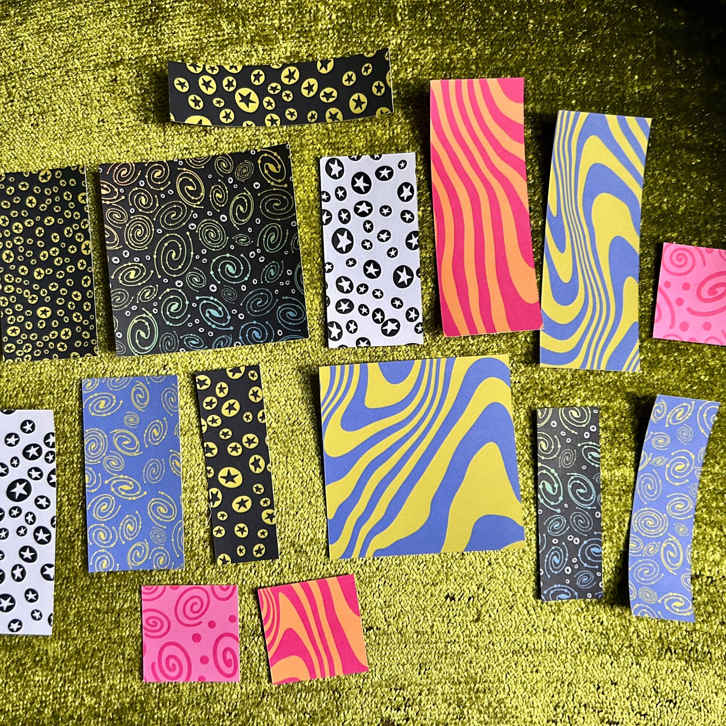 Collection of patterned paper strips on a textured green surface