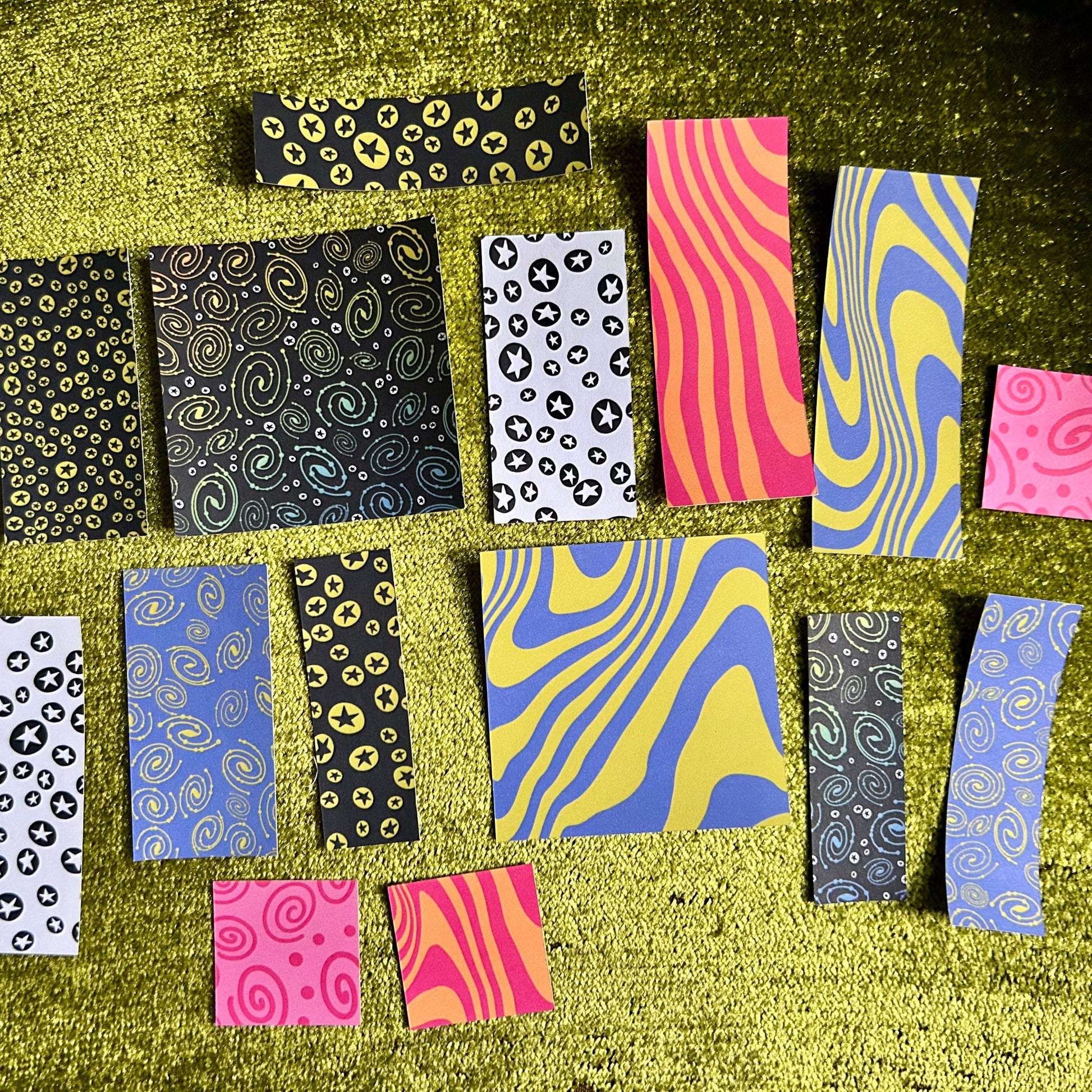 Collection of patterned paper strips on a textured green surface