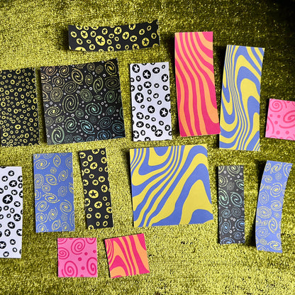 Collection of patterned paper strips on a textured green surface