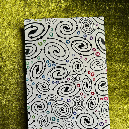 sticker paper with a black spiral pattern on a green textured surface