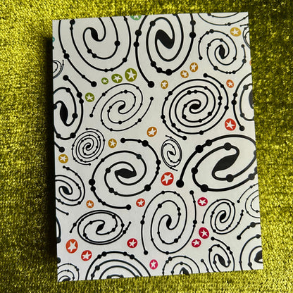 sticker paper with black spiral pattern on a textured green surface