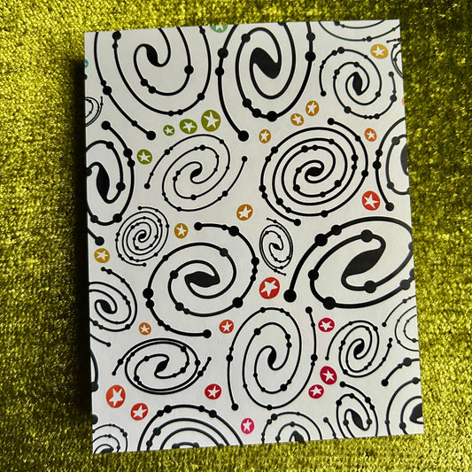 sticker paper with black spiral pattern on a textured green surface