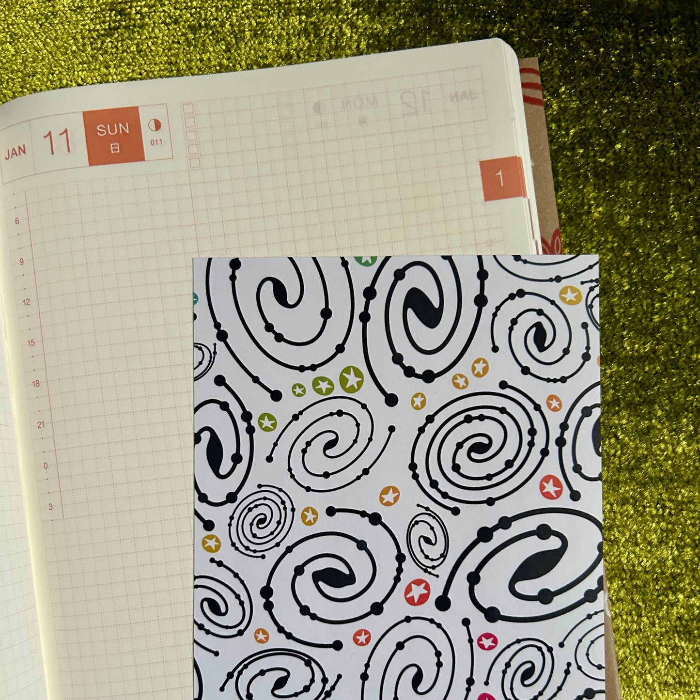 Notebook with a patterned cover on a grassy background
