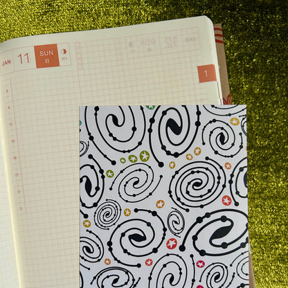 Notebook with a patterned cover on a grassy background