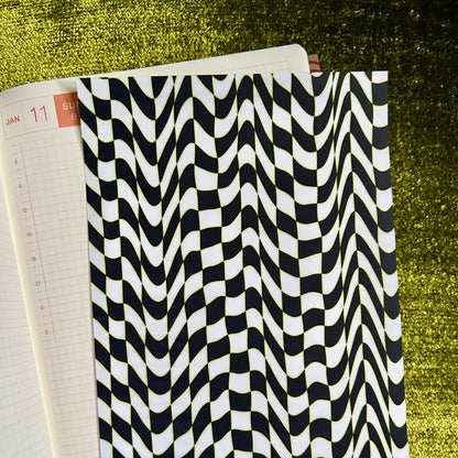 Black and white checkered sticker sheet on a green textured surface