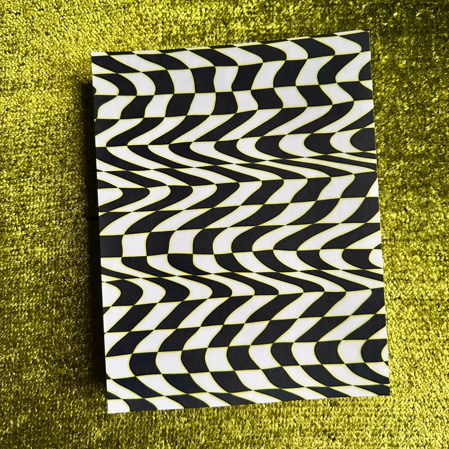 sticker sheet with black and white wavy pattern on a green textured surface