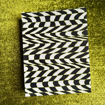 sticker sheet with black and white wavy pattern on a green textured surface