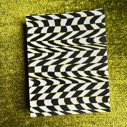 sticker sheet with black and white wavy pattern on a green textured surface