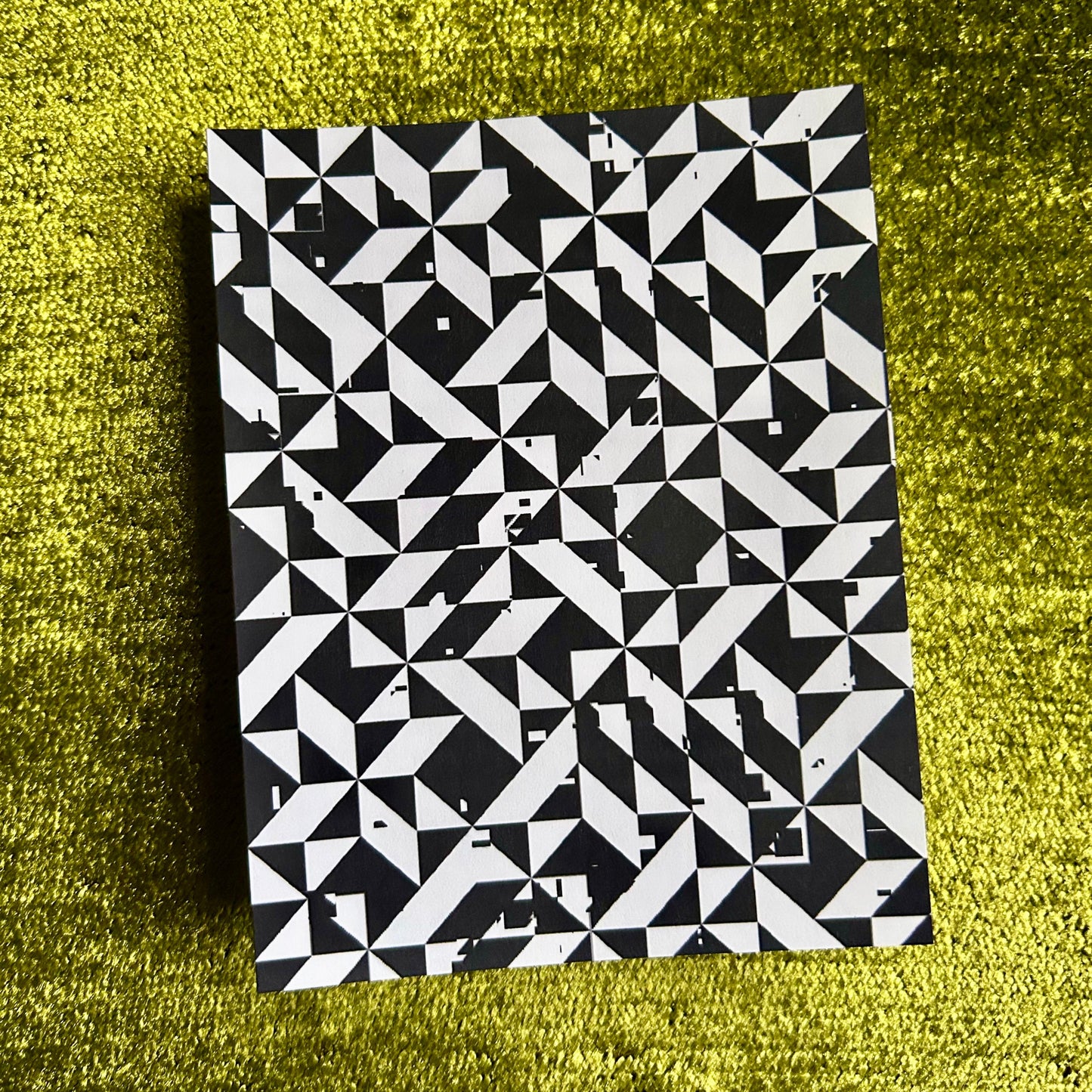 Black and white geometric patterned sticker sheet on a green textured surface