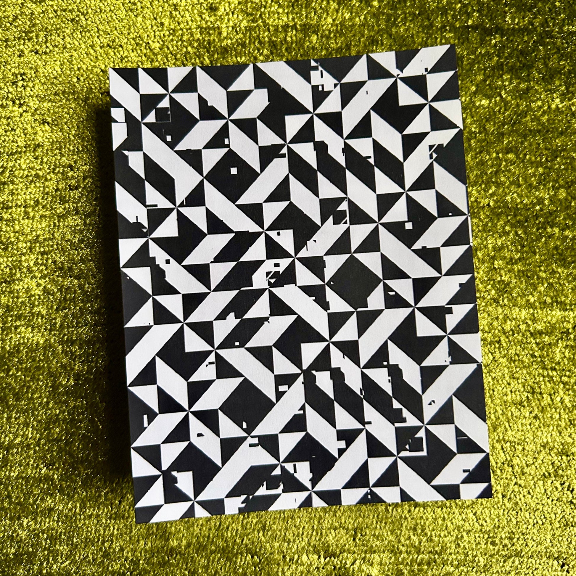 Black and white geometric patterned sticker sheet on a green textured surface
