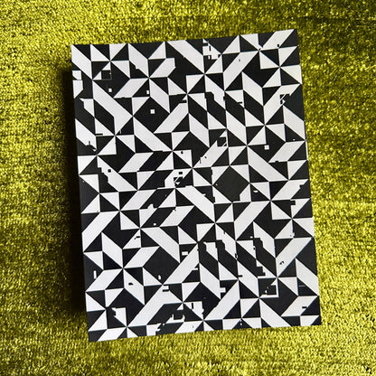 Black and white geometric patterned sticker sheet on a green textured surface