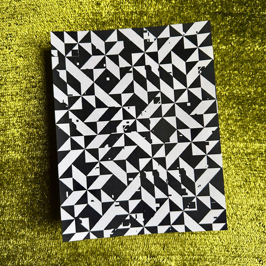 Black and white geometric patterned sticker sheet on a green textured surface