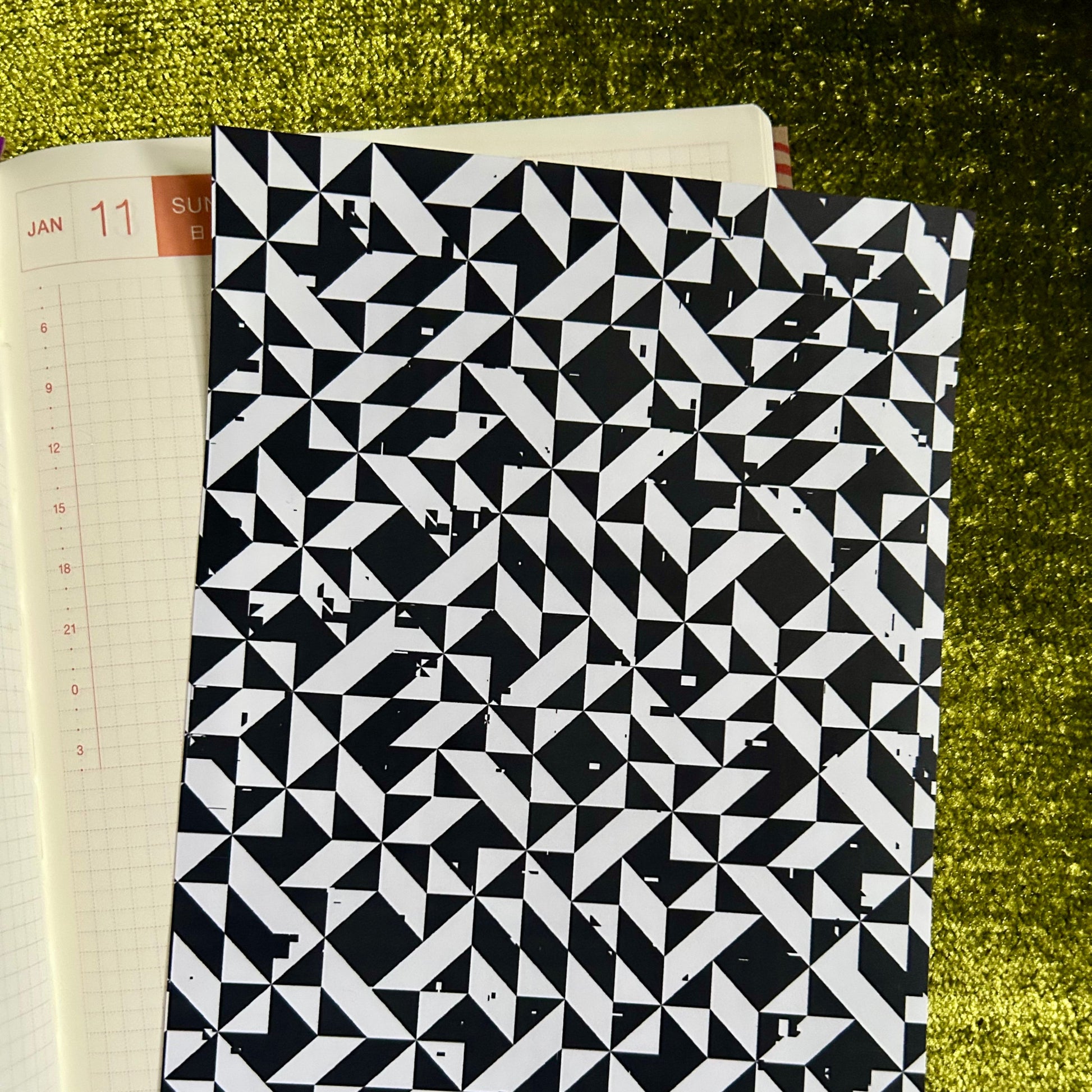 Black and white geometric patterned sticker sheet on a green textured surface