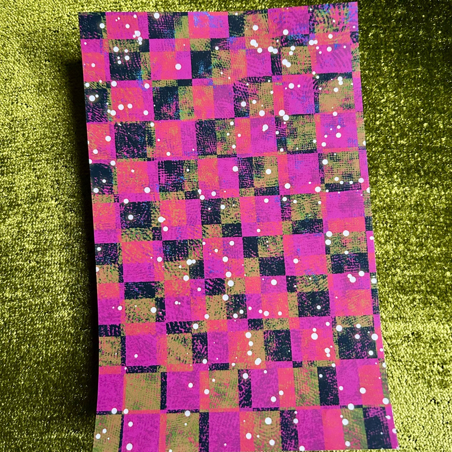 Checkered sticker paper with pink, purple, and green pattern on a green glittery background