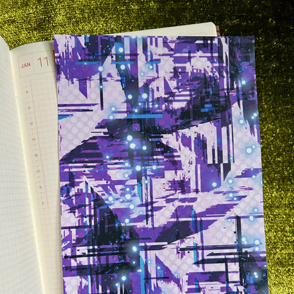 Notebook with a purple abstract pattern on a green textured surface