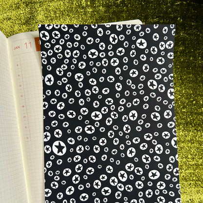 sticker sheet with black cover featuring white pattern on a green textured surface