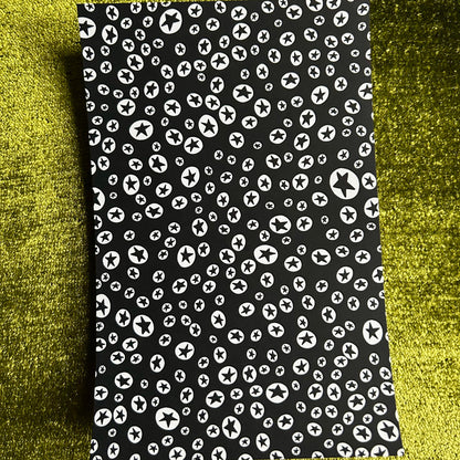 Black sticker sheet with white pattern on a green textured background