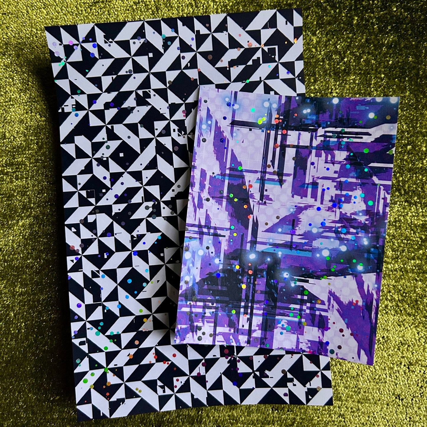 Two patterned sticker sheets stacked on a textured green surface