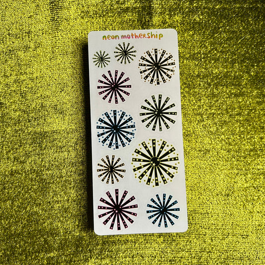 sticker sheet with black starburst designs on a green textured background