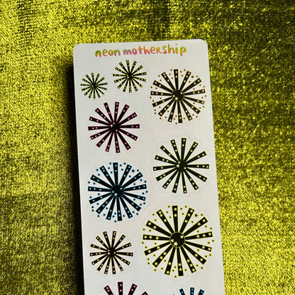 Sheet of decorative stickers with starburst designs on a green textured background