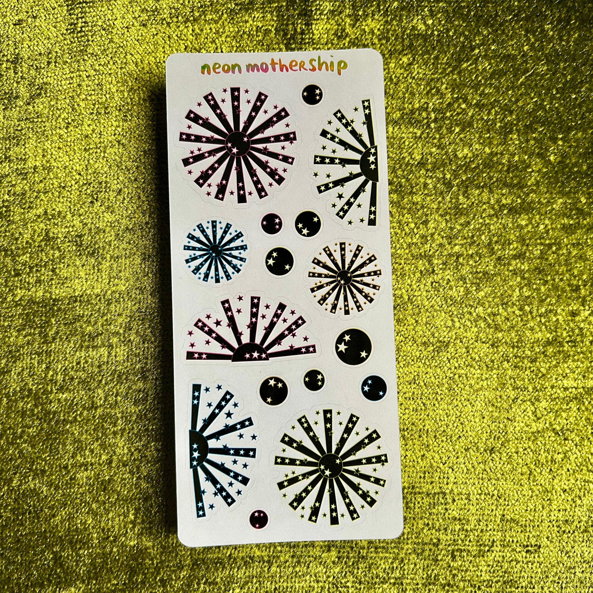 sticker sheet with neon and black starburst stickers on a green background