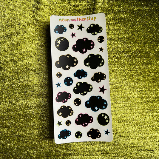 Sheet of black cloud and star-shaped stickers on a green textured background