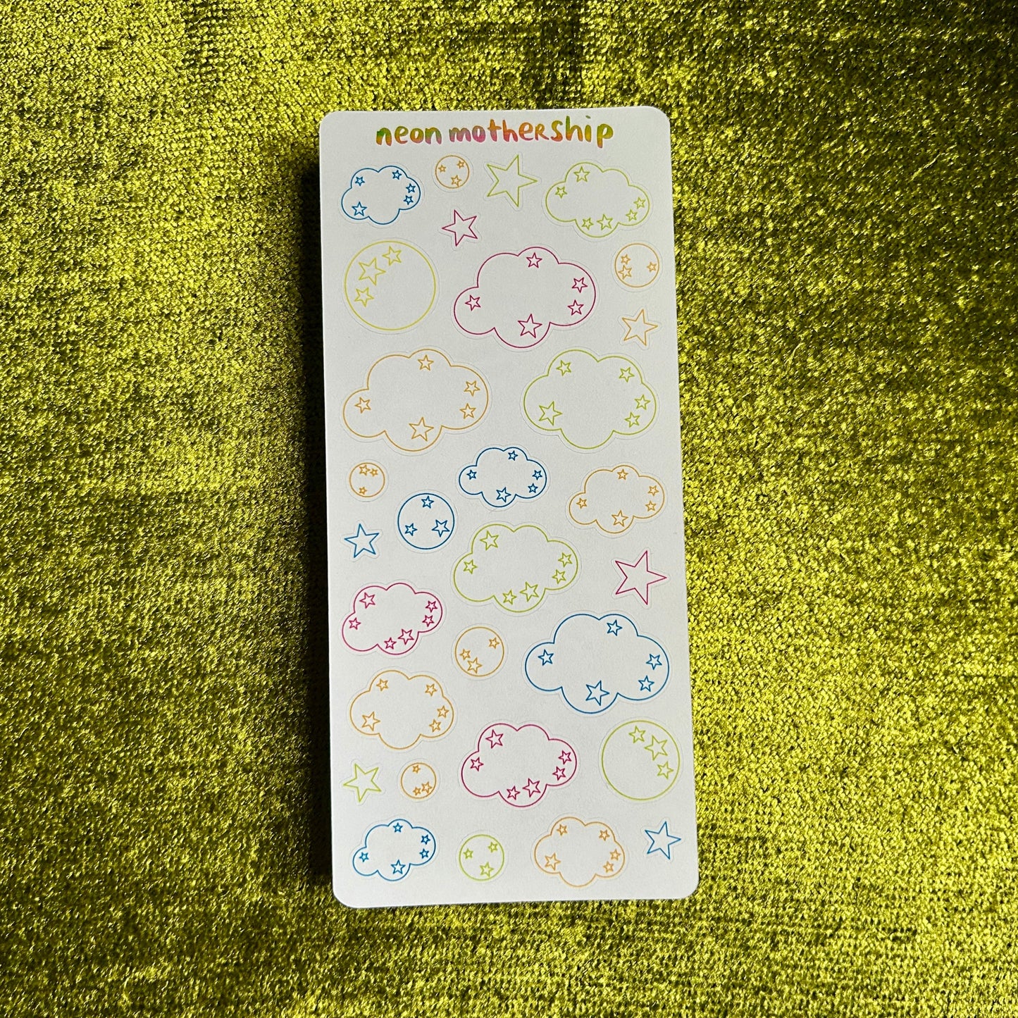 sticker sheet with clouds and start outlines on a green background